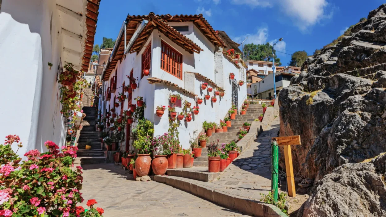 White houses and flowers on a street in San Blas, Cusco
