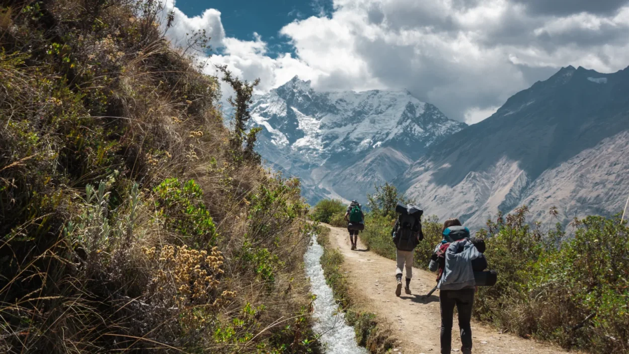 Hikers on the trail to Soraypampa with snow-capped peaks behind