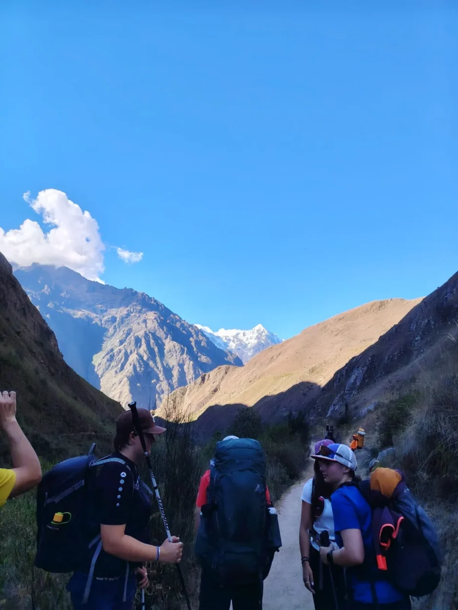 Hikers with backpacks looking at snow-capped mountains on the Inca Trail