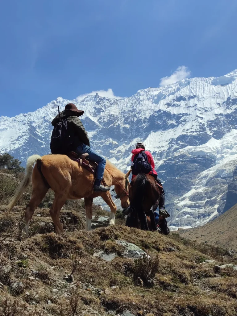 Riders on horseback below the Salkantay glacier on the way to Humantay Lake