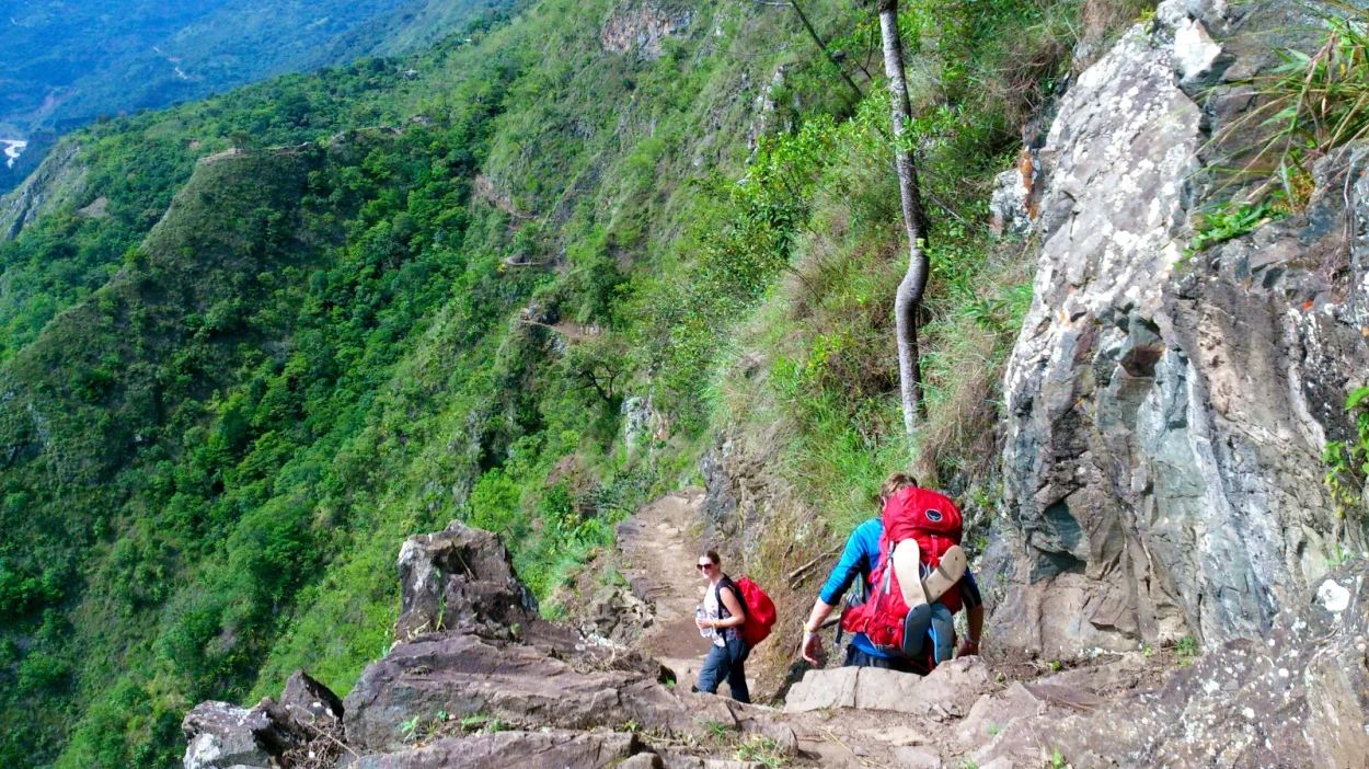 Hikers on a rocky path above the jungle valley on the Inca Jungle trek