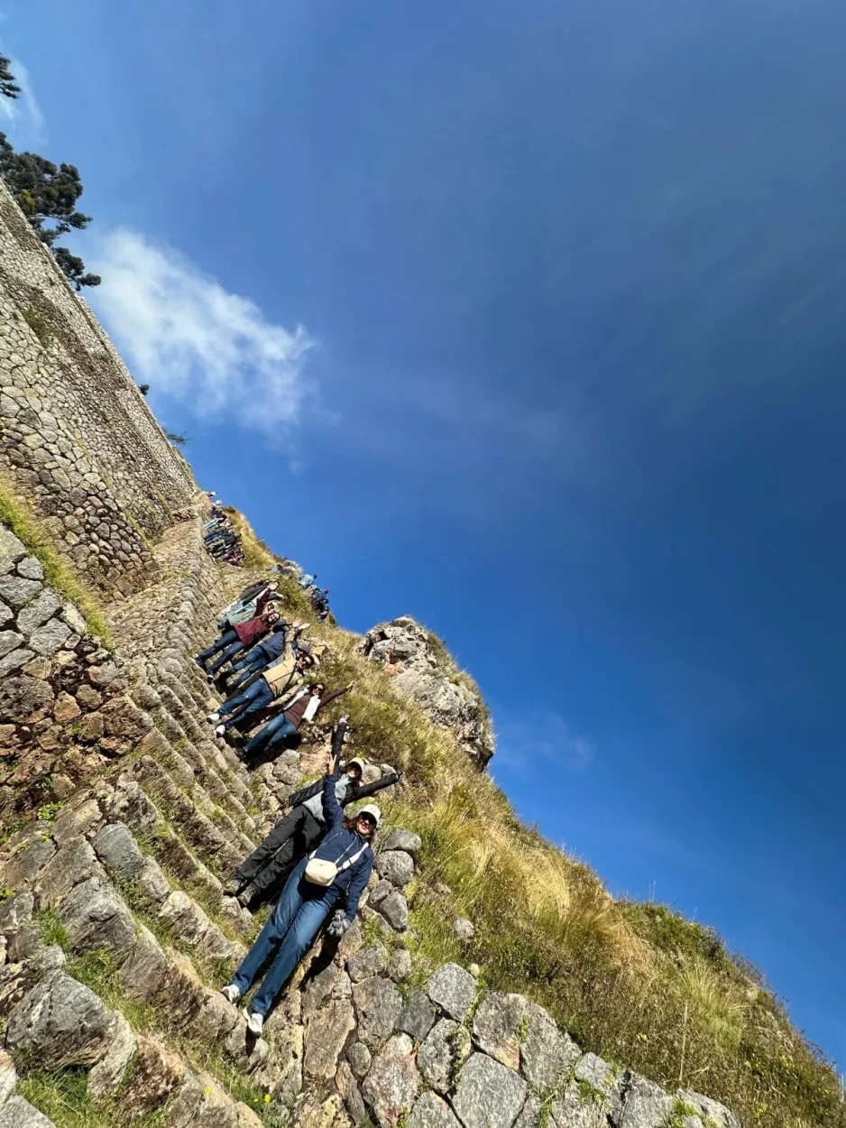 Travelers posing on an Inca stairway along the terrace walls of Tipón